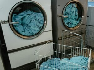 Industrial washing machines with blue towels in a laundry facility.